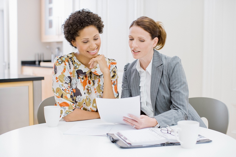 two woman reading a document